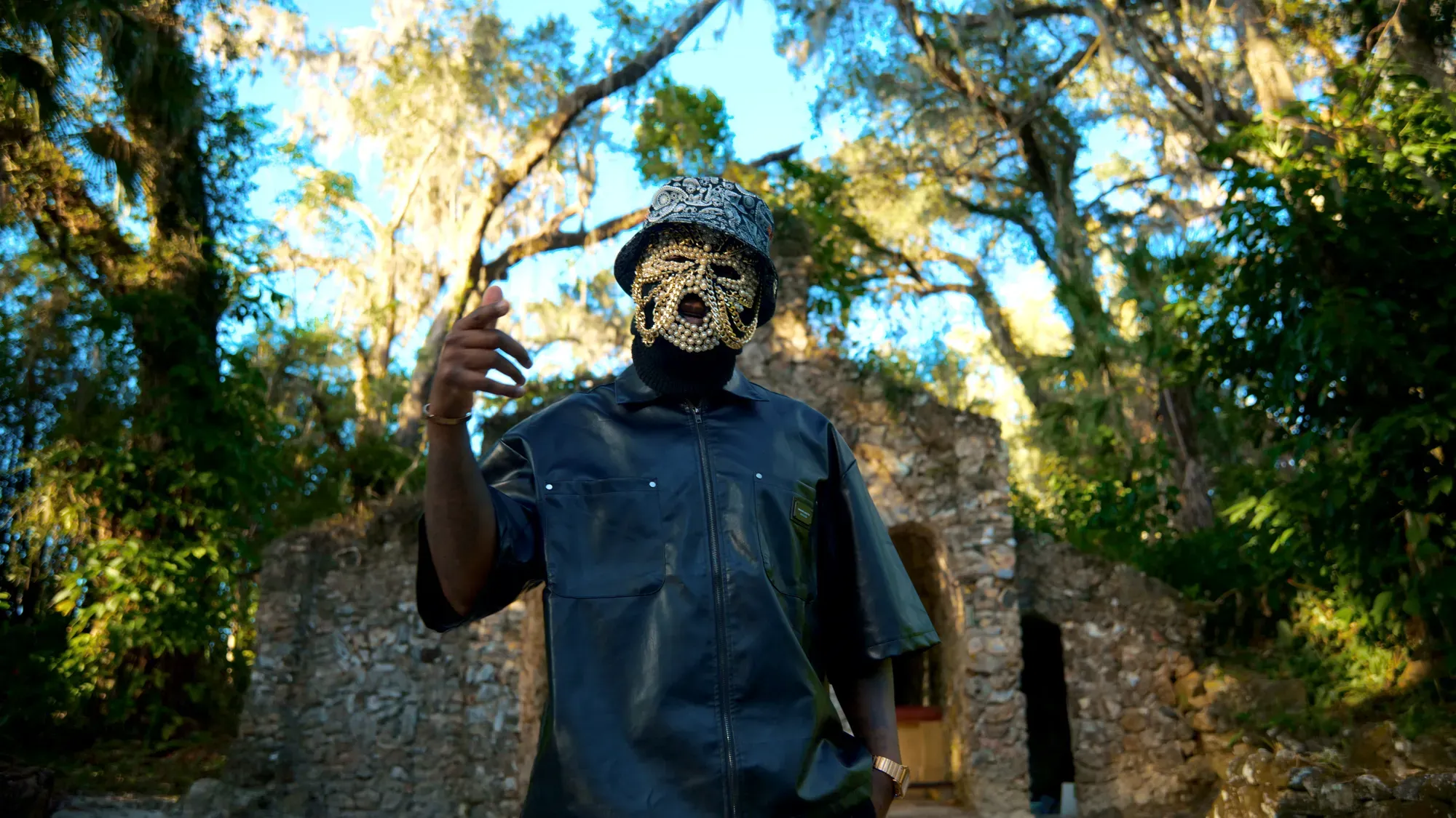 Pusha Preme performing in front of stone architecture.