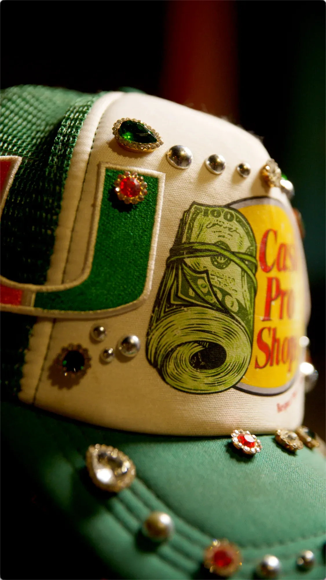 Close detail of a jewel-studded green and white cap.