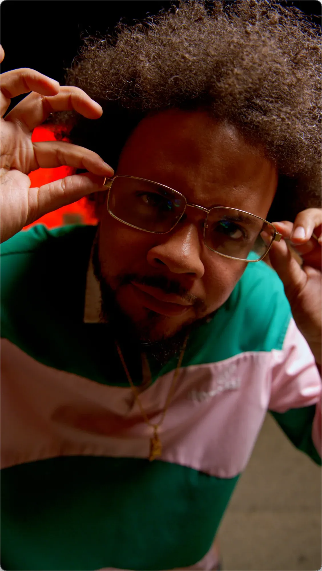 Close portrait of XLEONDUZ adjusting his glasses.